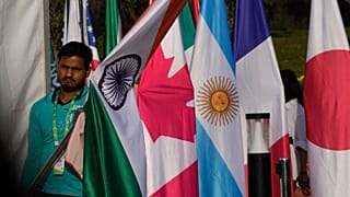 یک نفر در حال قرار دادن پرچم کشورهای شرکت کننده در اجلاس وزرای خارجه گروه بیست در هند در مارس ۲۰۲۳