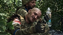 Un soldat ukrainien blessé levant son pouce en l'air attendant d'être évacué près de Bakhmout, 5 septembre 2023.