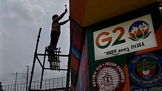 A worker paints an under-construction overhead bridge near the main venue of the G20 Summit, in New Delhi, India, Thursday, Aug. 24, 2023.