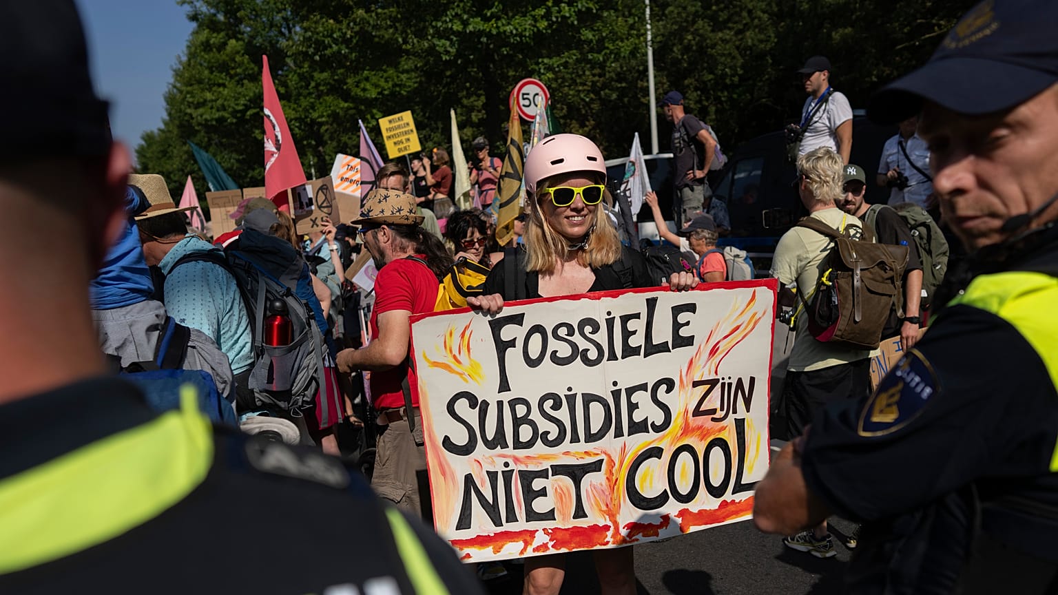 Una manifestante sostiene un cartel en el que se lee "Los subsidios fósiles no molan" en La Haya, Países Bajos, el sábado 9 de septiembre de 2023. 