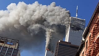 تظهر هذه الصورة الأرشيفية بتاريخ 11 سبتمبر 2001 الدخان المتصاعد من البرجين التوأمين المحترقين لمركز التجارة العالمي بعد اصطدام الطائرات المختطفة بالبرجين في مدينة نيويورك.