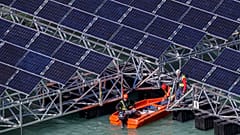 Workers assemble floating barges with solar panels on the 'Lac des Toules', an alpine reservoir lake, in Bourg-Saint-Pierre, Switzerland, 8 October 2019. 