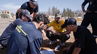 Equipas de emergência marroquina e espanhola discutem plano de resgate em campo militar na cidade de Amizmiz, perto de Marraquexe, Marrocos