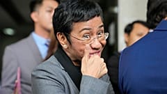 Filipino journalist Maria Ressa, 2021 Nobel Peace Prize winner and Rappler CEO, gestures as she talks to reporters after being acquitted