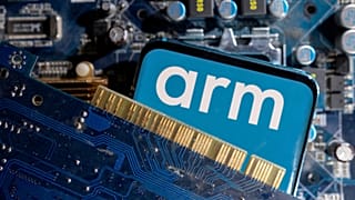 A smartphone with a displayed Arm Ltd logo is placed on a computer motherboard