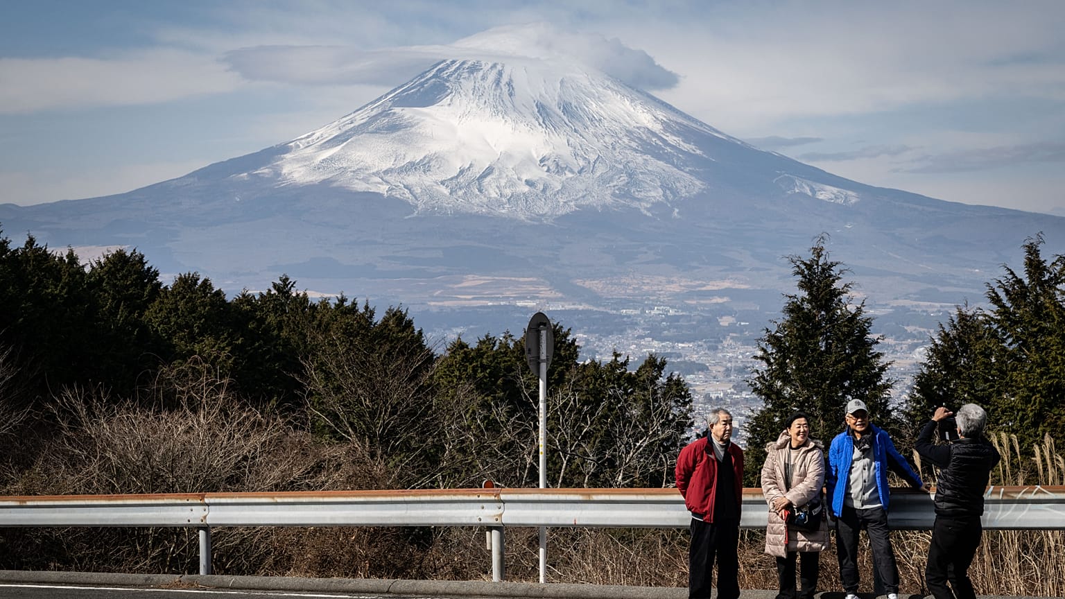 People having their photographs taken in front of Japan's Mount Fuji