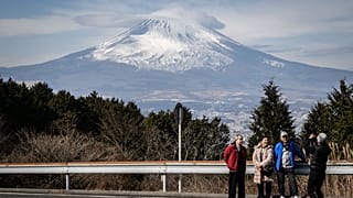 People having their photographs taken in front of Japan's Mount Fuji