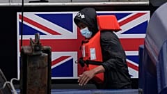 A man thought to be a migrant who made the crossing from France disembarks after being picked up in the English Channel by a British border force vessel.
