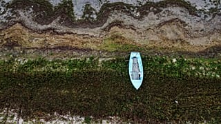 A rowing boat rests at last year's water line at Prespa lake in the village of Stenje, North Macedonia 6 September 2023.