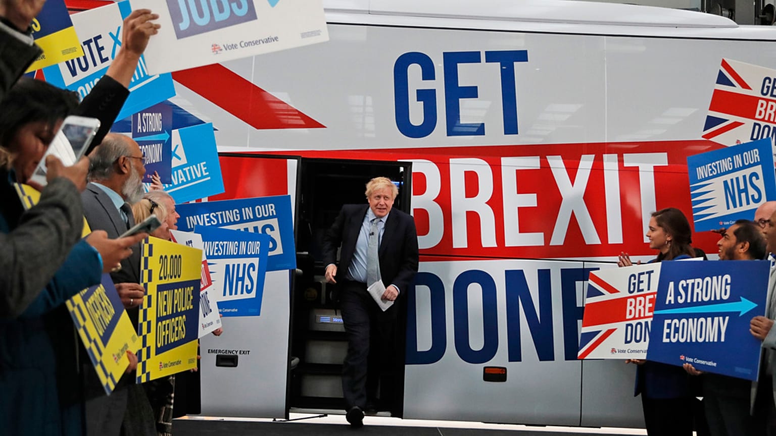 L'allora primo ministro Boris Johnson si rivolge ai suoi sostenitori prima di salire sul pullman della sua campagna elettorale per le elezioni generali a Manchester, in Inghilterra, nel 2019.