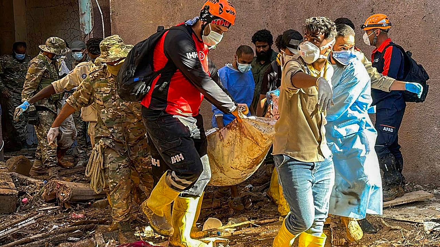 In this photo provided by Turkey's IHH humanitarian aid group, rescuers retrieve the body of a flooding victim in Derna, Libya, Wednesday, Sept.13, 2023. 