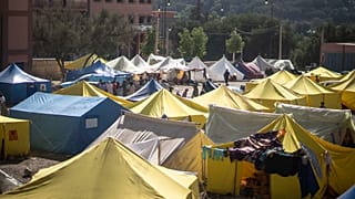 Pessoas desalojadas pelo terramoto à porta das suas tendas na cidade de Amizmiz, nos arredores de Marraquexe, esta quinta-feira.