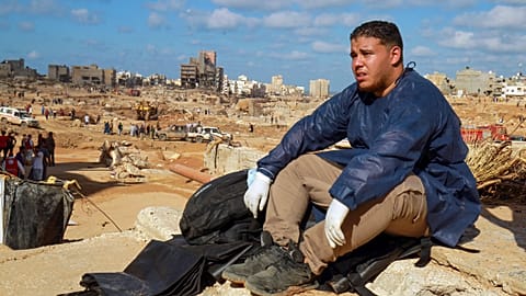 عامل إنقاذ متطوّع يجلس على ركام بناية دمرتها السيول الناجمة عن انهيار سد درنة. التاريخ 14.09.23