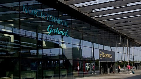 Passengers walk into the Departures entrance at the North Terminal of Gatwick Airport. 