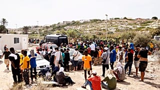 Des migrants devant le centre d'accueil sur l'île sicilienne de Lampedusa, dans le sud de l'Italie, samedi 16 septembre 2023.
