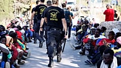 Sicherheitspersonal und Geflüchtete auf Lampedus 