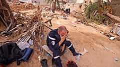 Membro de uma equipa de resgate entre os escombros em Derna.