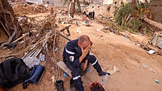Membro de uma equipa de resgate entre os escombros em Derna.
