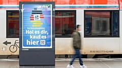 A man passes by an advertising for the Deutschlandticket (Germany Ticket) at a train station in Frankfurt, Germany, Monday, May 1, 2023.