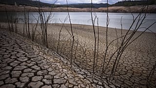 Rissige Erde ist am Sau-Stausee nördlich von Barcelona, Spanien, am 18\. April 2023 zu sehen.
