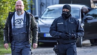 Rendőr kíséri el Sven Krueger neonáci aktivistát a házkutatása idején