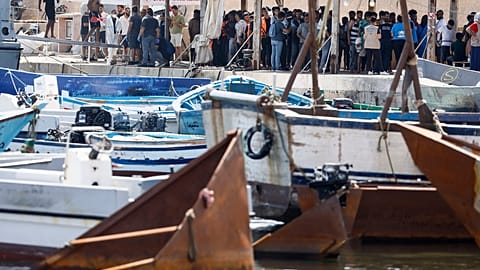 Migrants stand on the dock of the port of the Sicilian island of Lampedusa, southern Italy, Monday, Sept. 18, 2023