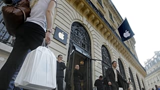People leave the Apple store in Paris Friday, March 16, 2012.