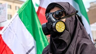 Mahsa Amini'nin ölümünün birinci yıl dönümü vesilesiyle antik Kolezyum yakınlarında düzenlenen yürüyüş sırasında solunum maskesi takan bir protestocu