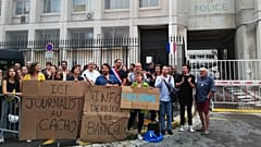 Protesters hold placards reading 'information behind bars' and 'journalist in jail here' as they demonstrate in front of the police headquarters in Marseille.