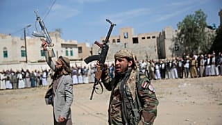 مقاتلون حوثيون مسلحون يحضرون موكب تشييع