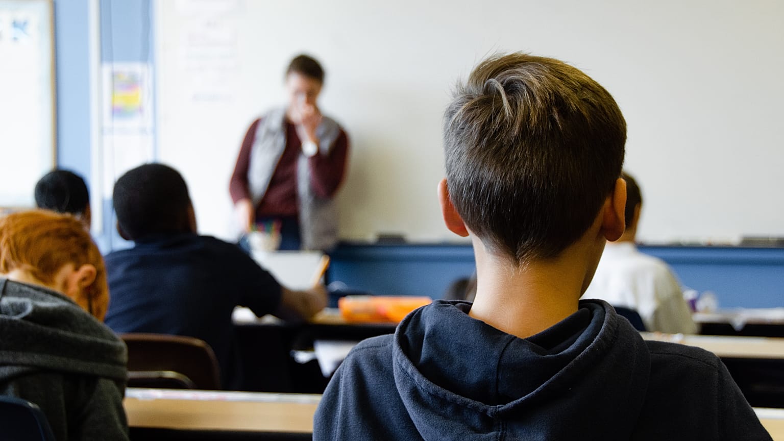 Students listening to the teacher in the classroom.