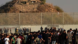 Des manifestants palestiniens se rassemblent devant un poste de l'armée et la clôture lors d'affrontements avec les forces de sécurité israéliennes le long de la bande de Gaza