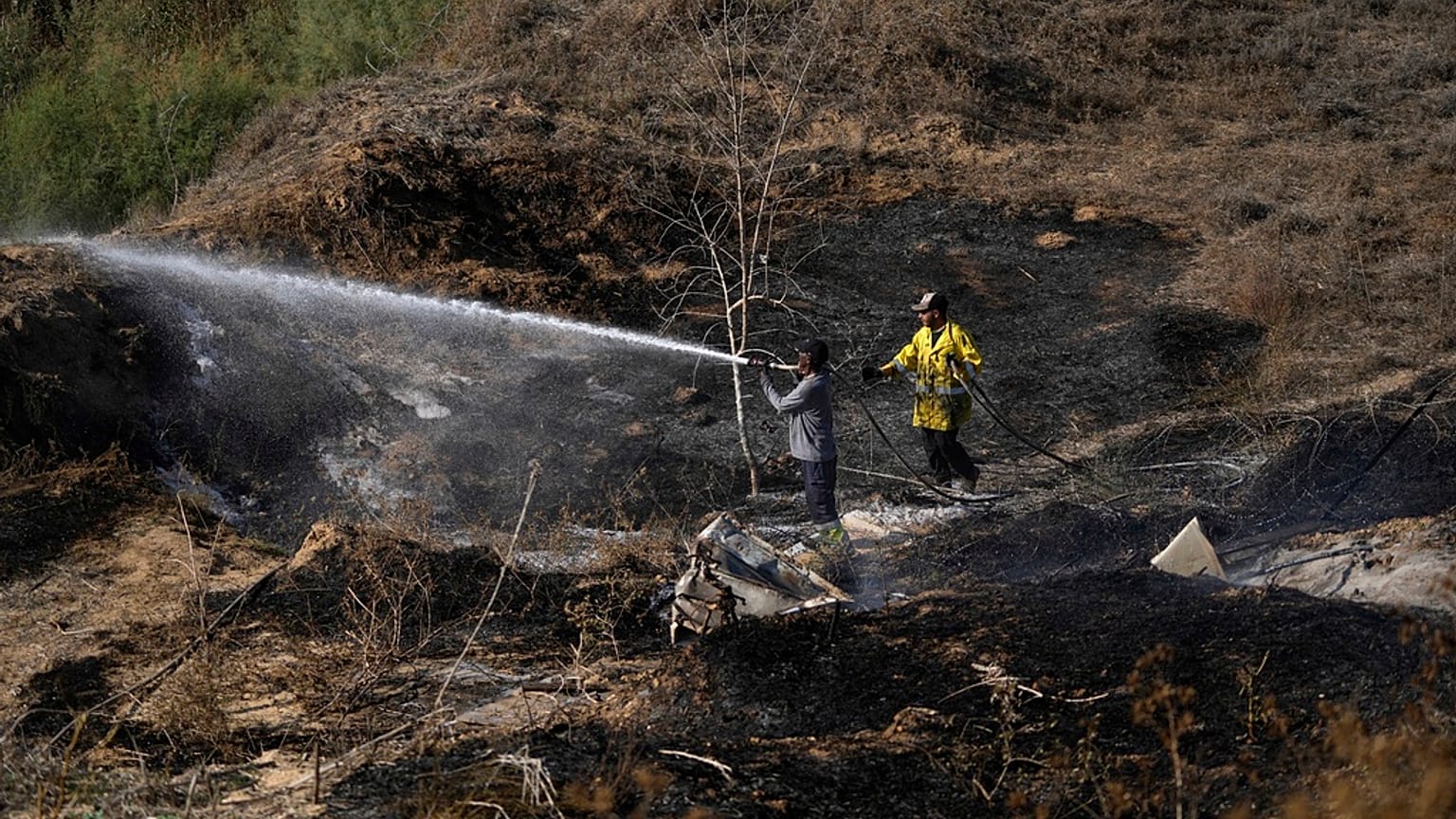 Bombeiros extinguiem incêndios provocados por balões incendiários lançados a partir da Faixa de Gaza, para o território de Israel,  22 de setembro de 2023. 