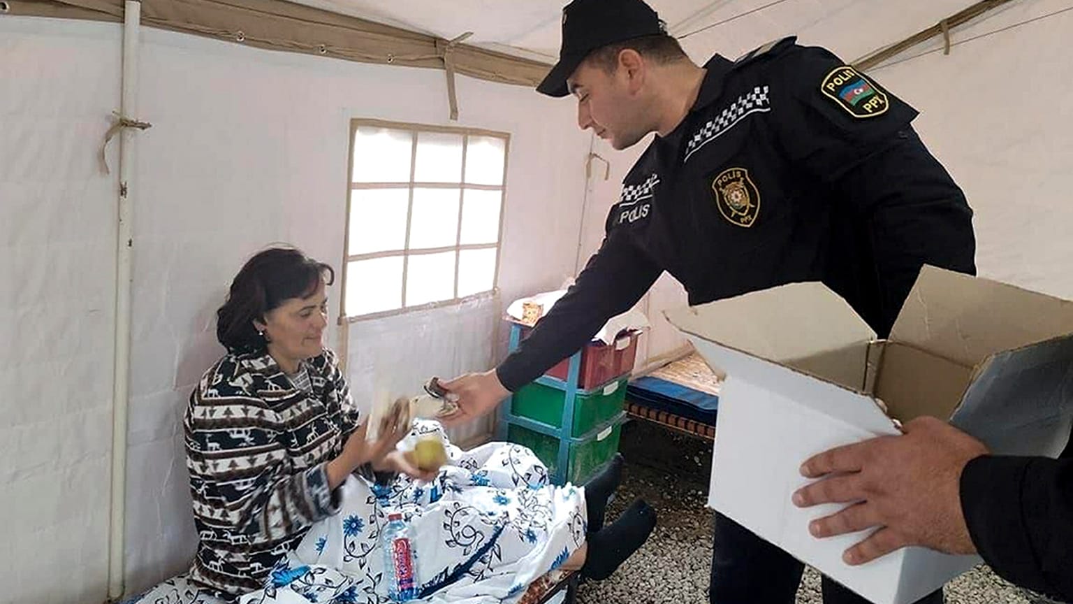 Ein aserbaidschanischer Polizist verteilt Nahrung in Berg-Karabach am 22.9.2023