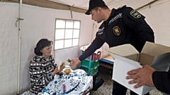 Ein aserbaidschanischer Polizist verteilt Nahrung in Berg-Karabach am 22.9.2023