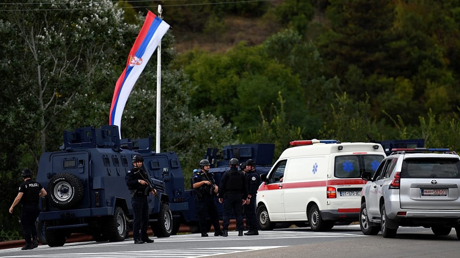 Kosovo's police officers stand guard at the entrance of the village of Banjska on Sunday, after one policeman was killed and another wounded i