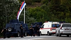 Kosovo's police officers stand guard at the entrance of the village of Banjska on Sunday, after one policeman was killed and another wounded i