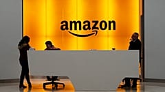 FILE - People stand in the lobby for Amazon offices in New York
