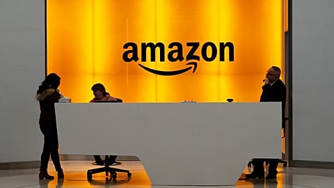 FILE - People stand in the lobby for Amazon offices in New York