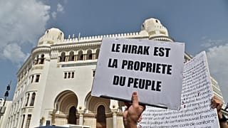 لافتة كُتبت عليها عبارة "الحراك هو ملك للشعب" أثناء مظاهرة ضد الحكومة الجزائرية في ربيع عام 2021