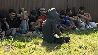 Közel-keleti illegális bevándorlók rendőri őrizet alatt a szlovákiai Ipolynagyfaluban