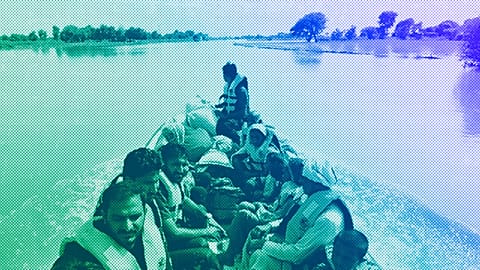 Rescue workers use a boat to evacuate villagers from a flooded area of Bahawalnagar district in Pakistan's Punjab province, August 2023