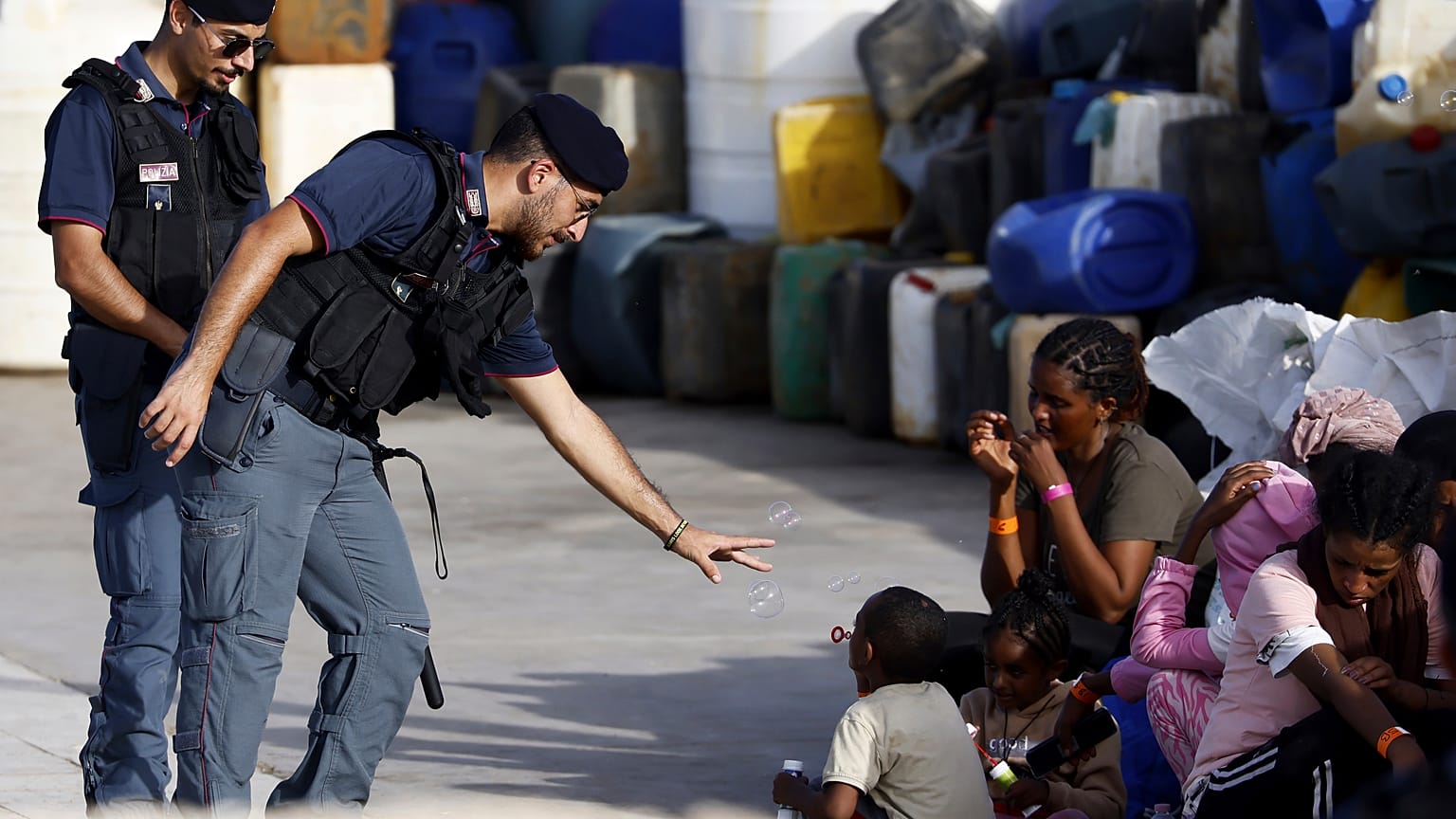 Polizisten und Flüchtlinge auf Lampedusa