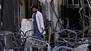 A health worker collects the remains of victims at the site of a fatal fire, in the district of Hamdaniya, Nineveh province, Iraq, Thursday, Sept. 28, 2023.