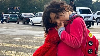 A child holds a toy as ethnic Armenians gather in hope to leave Nagorno-Karabakh region for Armenia.