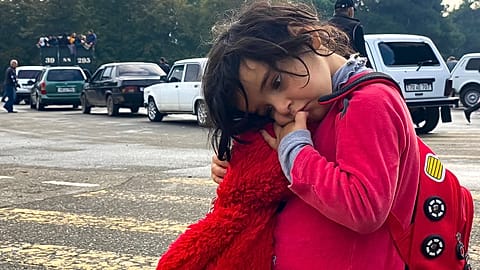 A child holds a toy as ethnic Armenians gather in hope to leave Nagorno-Karabakh region for Armenia.