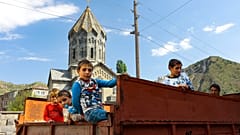 Ethnic Armenian children from Nagorno-Karabakh look from a truck after arriving in Armenia's Goris in Syunik region, Armenia, on Thursday, Sept. 28, 2023.