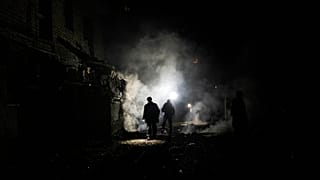 FILE - Resident walks amid debris after a Russian attack in Kherson, southern Ukraine, Nov. 24, 2022. 