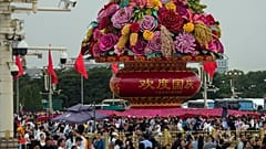 Visitors gather near a giant flower basket on display at the crowded Tiananmen Square to celebrate the 74th anniversary of the founding of the People's Republic of China,.