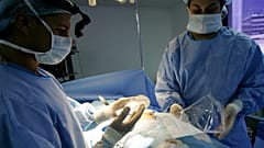 جراح التجميل الدكتور إسياس بيلو يحمل ثديًا من السيليكون أثناء جراحة زراعة الثدي في كاراكاس، فنزويلا، 21 سبتمبر، 2005.